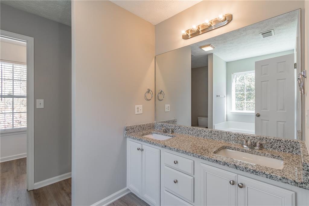 5014 Red Oak Lane Gainesville, GA 30506 - Photo 24 of 43 a bathroom with a granite countertop double vanity sink and mirror