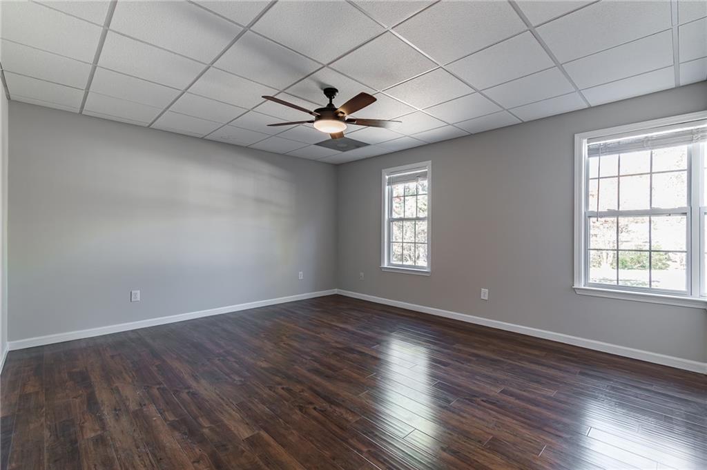 5014 Red Oak Lane Gainesville, GA 30506 - Photo 36 of 43 an empty room with wooden floor chandelier fan and windows