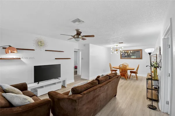 a living room with furniture kitchen view and a fireplace