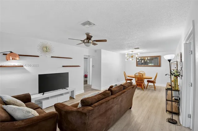 a living room with furniture kitchen view and a fireplace