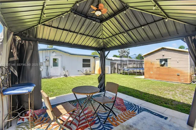 a view of a chair and table in backyard of the house