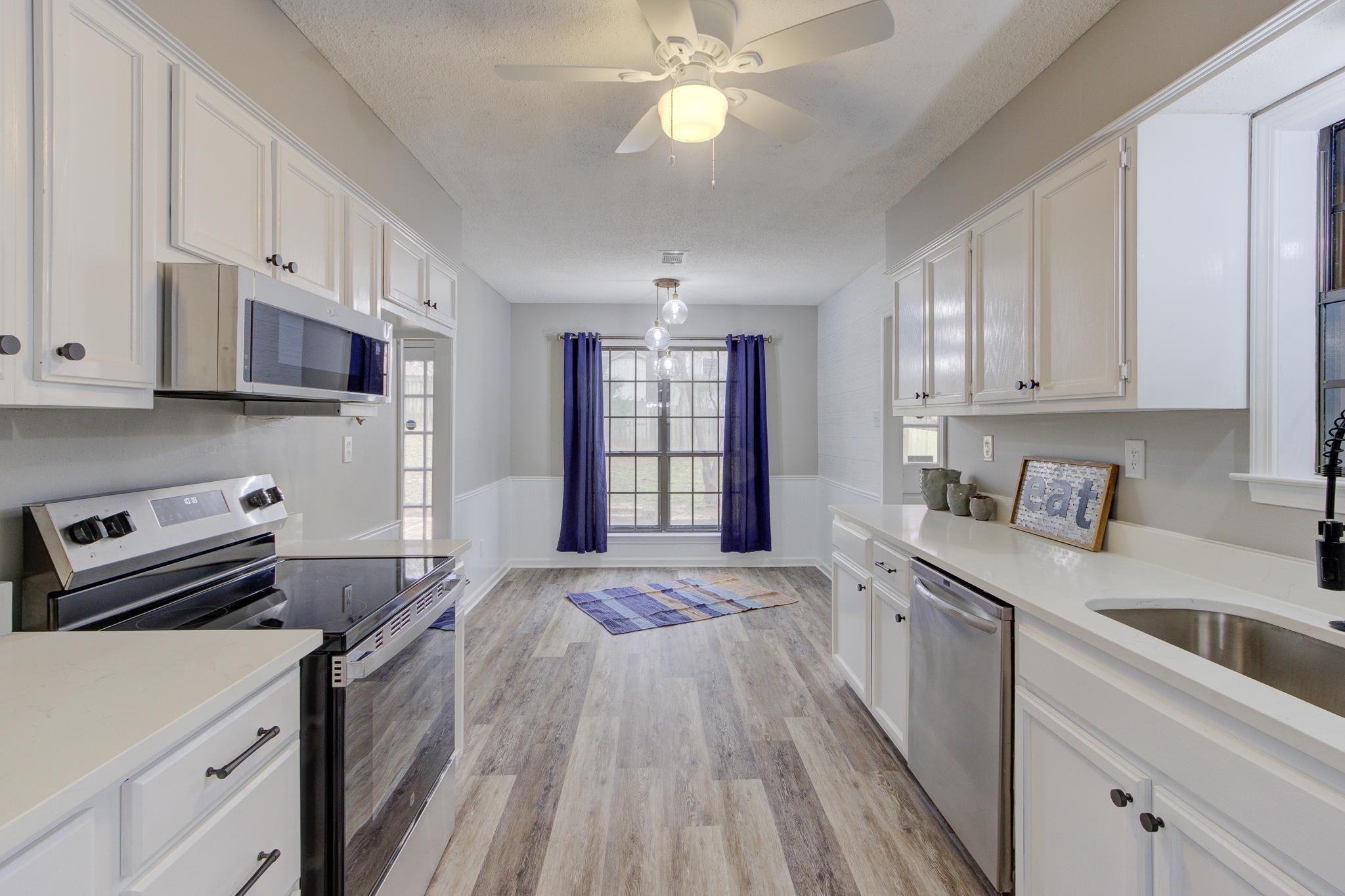 5991 Explorer Road Bartlett, TN 38134 - Photo 12 of 39 Kitchen with LVP floors, white cabinets, stainless steel appliances, and light quartz countertops