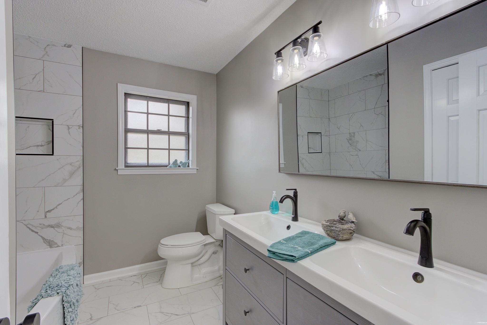 5991 Explorer Road Bartlett, TN 38134 - Photo 24 of 39 Guest bathroom with double vanity, new lighting, matte black finishes, Statuario Matte Porcelain tile