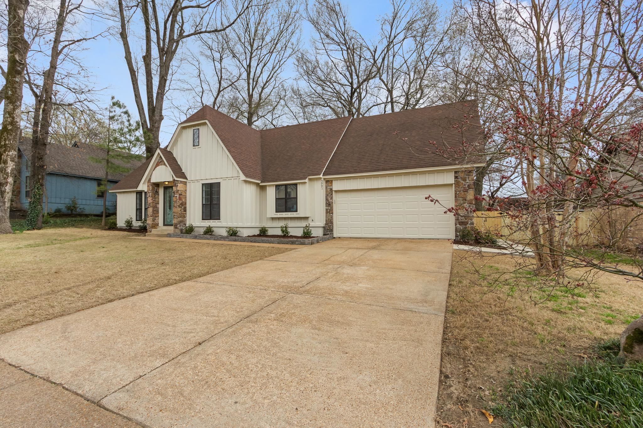 5991 Explorer Road Bartlett, TN 38134 - Photo 3 of 39 View of front of house featuring a shingled roof, a front lawn, concrete driveway, a garage, and stone siding