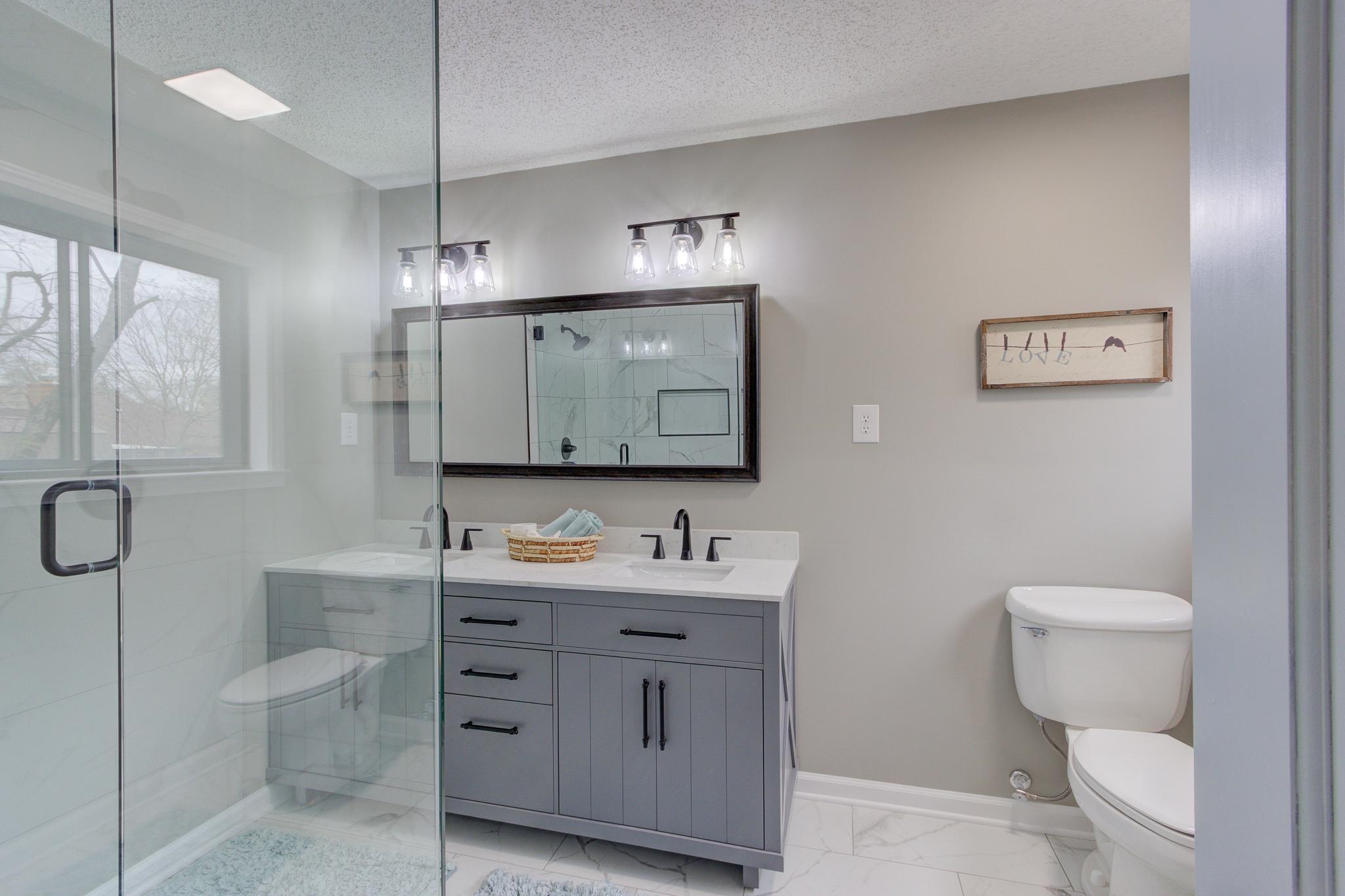 5991 Explorer Road Bartlett, TN 38134 - Photo 35 of 39 Primary bathroom with a glass shower stall, double vanity, Statuario Matte Porcelain tile, matte black finishes.