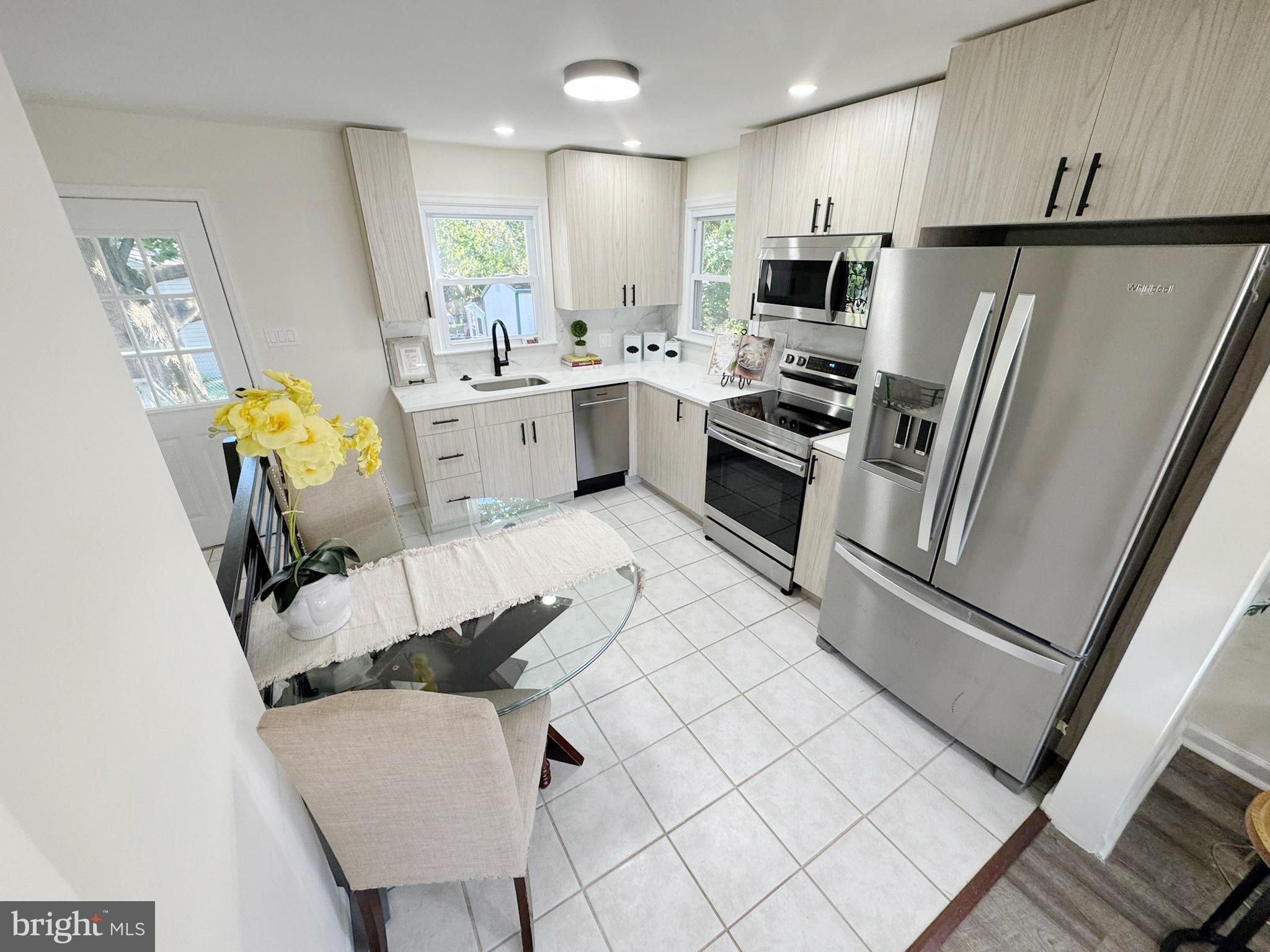 1210 Brownsville Road Langhorne, PA 19047 - Photo 4 of 13 a kitchen with stainless steel appliances kitchen island granite countertop a refrigerator and a stove top oven