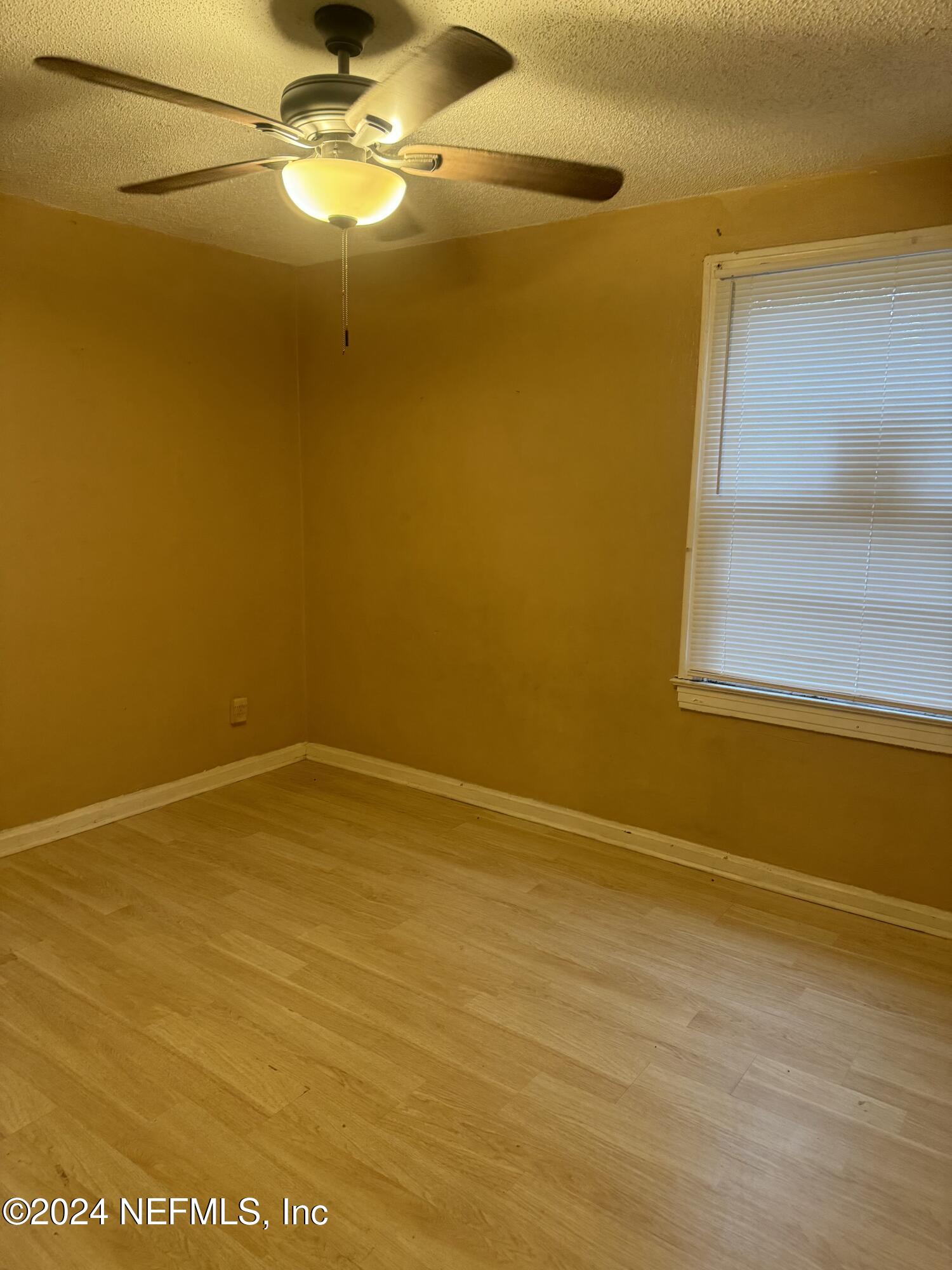 822 Saranac Street Jacksonville, FL 32254 - Photo 3 of 17 a view of empty room with a window and wooden floor