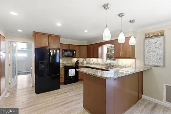 a kitchen with stainless steel appliances granite countertop a sink refrigerator and microwave