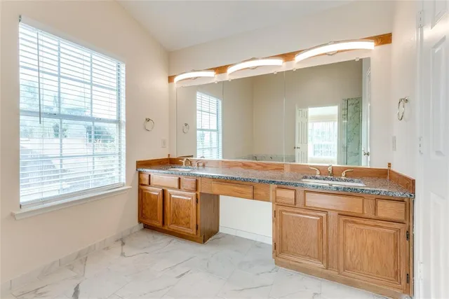 a spacious bathroom with a granite countertop sink and a large mirror