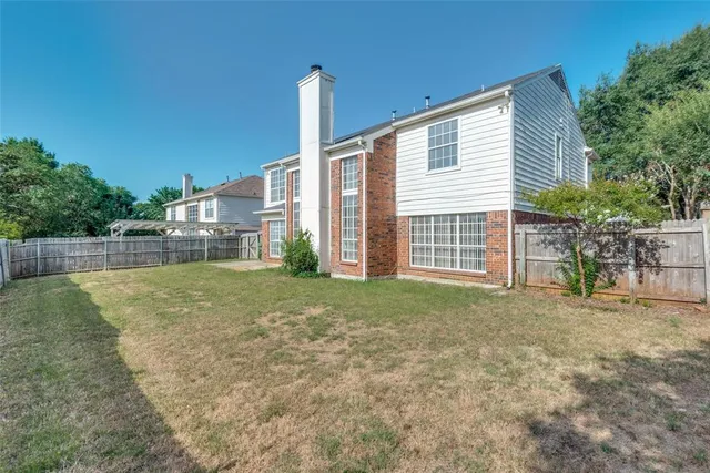 a view of a house with backyard and a tree