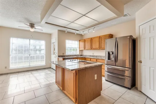a kitchen with stainless steel appliances granite countertop a stove a refrigerator and a sink