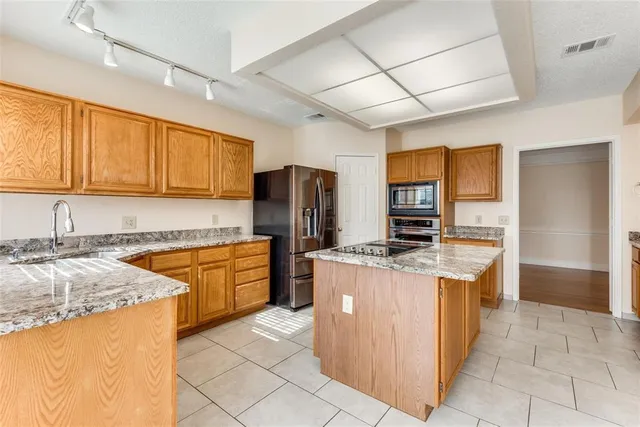 a kitchen with stainless steel appliances granite countertop a sink stove and refrigerator