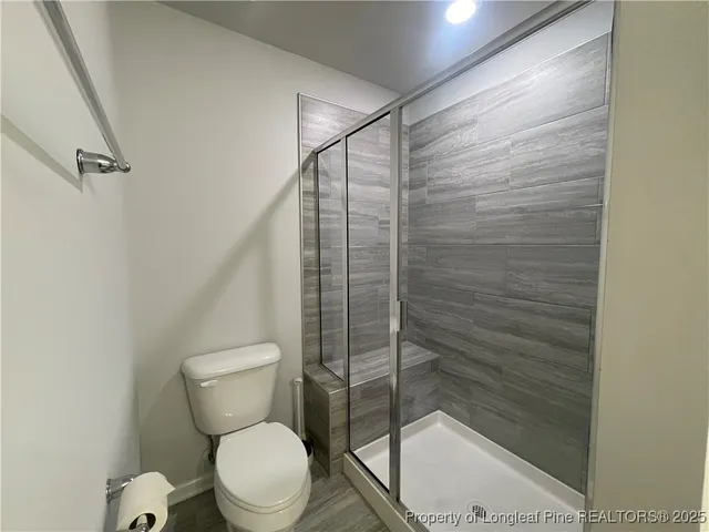 a white toilet sitting next to a shower