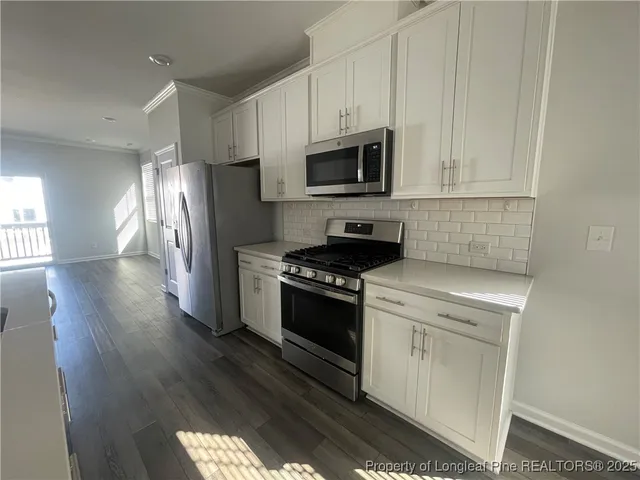 a kitchen with stainless steel appliances white cabinets and a refrigerator