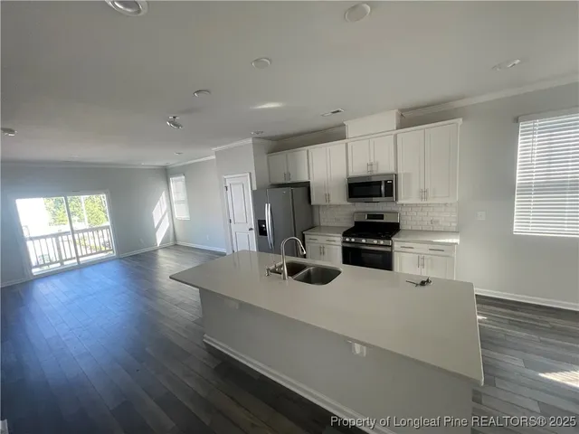 a kitchen with a refrigerator a stove cabinets and a wooden floor