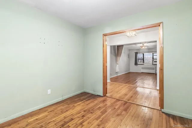 a view of a room with wooden floor and a bathroom