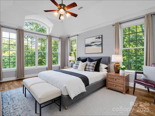 a spacious bedroom with a bed a couch and a large window