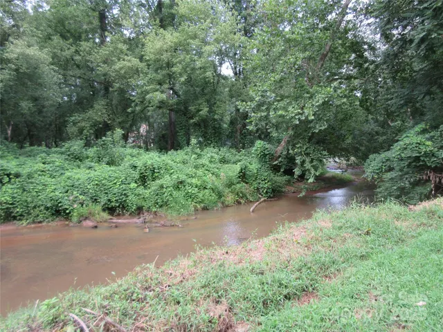 an aerial view of a house with a yard and greenery
