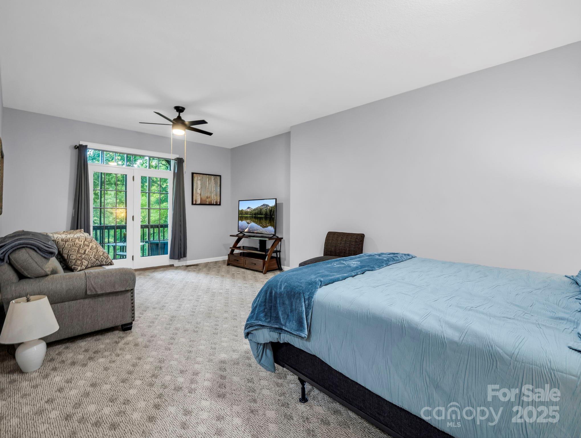34 West Rambling Creek Tryon, NC 28782 - Photo 27 of 48 a spacious bedroom with a bed a couch and a large window
