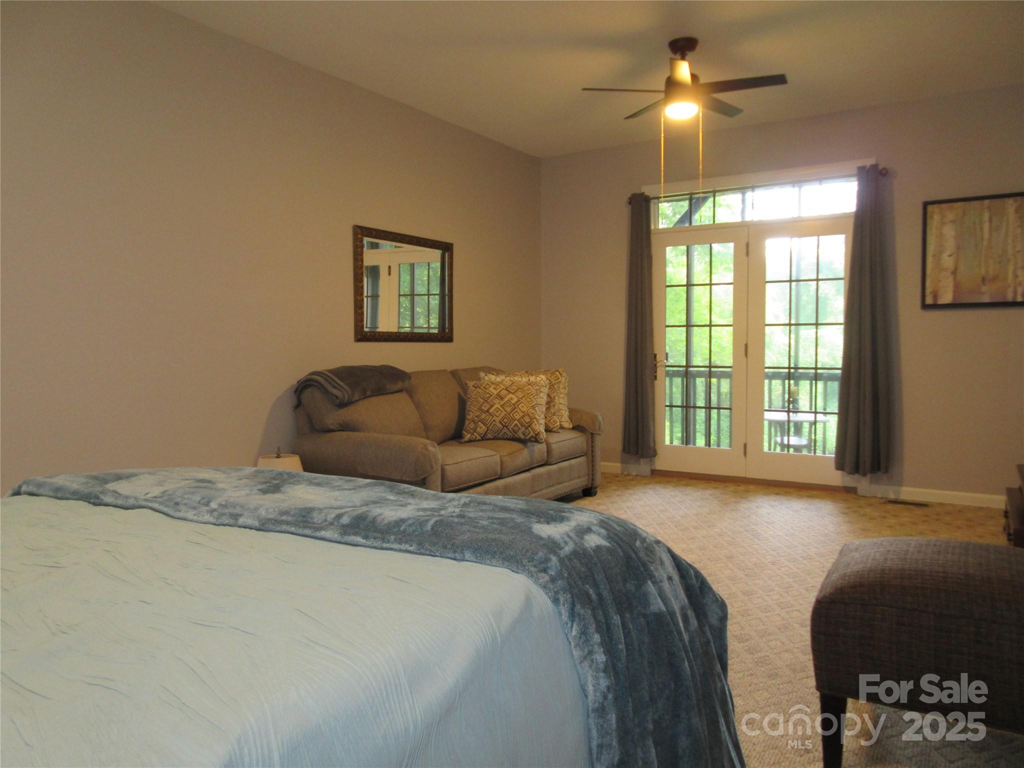 34 West Rambling Creek Tryon, NC 28782 - Photo 44 of 48 a spacious bedroom with a bed and a chandelier