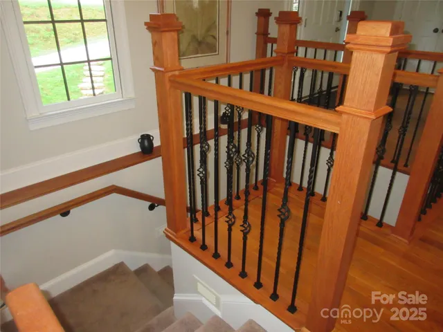 a view of staircase with railing and a window