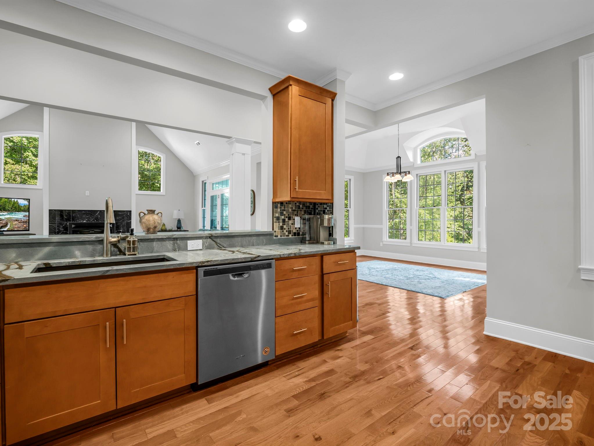 34 West Rambling Creek Tryon, NC 28782 - Photo 9 of 48 a large kitchen with kitchen island granite countertop wooden floors white cabinets a sink and a window