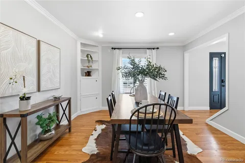 a kitchen with stainless steel appliances kitchen island granite countertop a table chairs in it and wooden floors