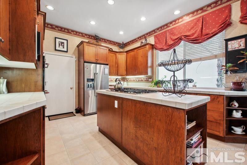 1825 Caughlin Creek Road Reno, NV 89519 - Photo 12 of 40 a kitchen with stainless steel appliances granite countertop a sink and a refrigerator