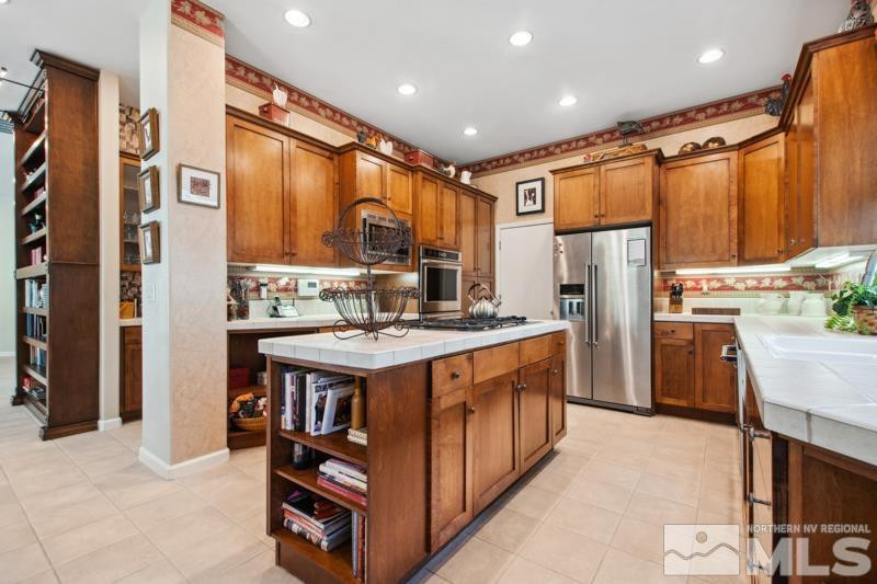 1825 Caughlin Creek Road Reno, NV 89519 - Photo 13 of 40 a kitchen with stainless steel appliances granite countertop a refrigerator a stove and a microwave