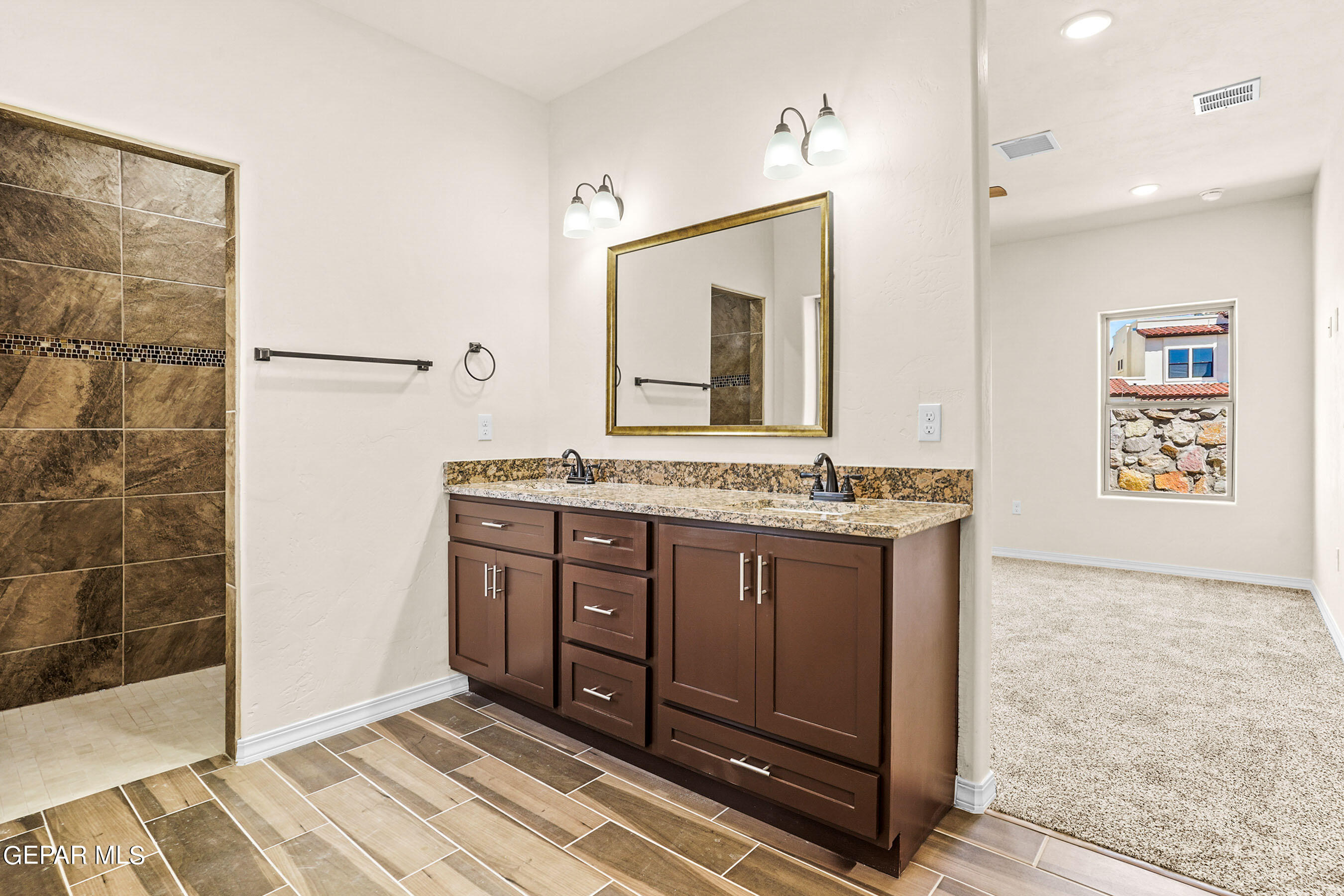 871 Country Club Road, Unit 4E El Paso, TX 79932 - Photo 5 of 34 a spacious bathroom with a granite countertop sink a mirror and a