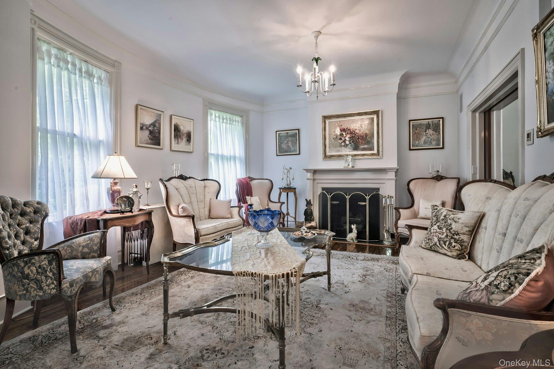 89 Duck Pond Road Glen Cove, NY 11542 - Photo 17 of 48 a living room with furniture a chandelier and a fireplace
