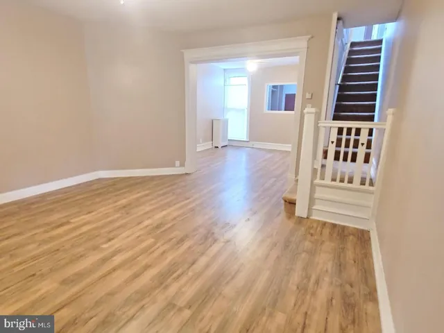 a view of a livingroom with wooden floor and stairs