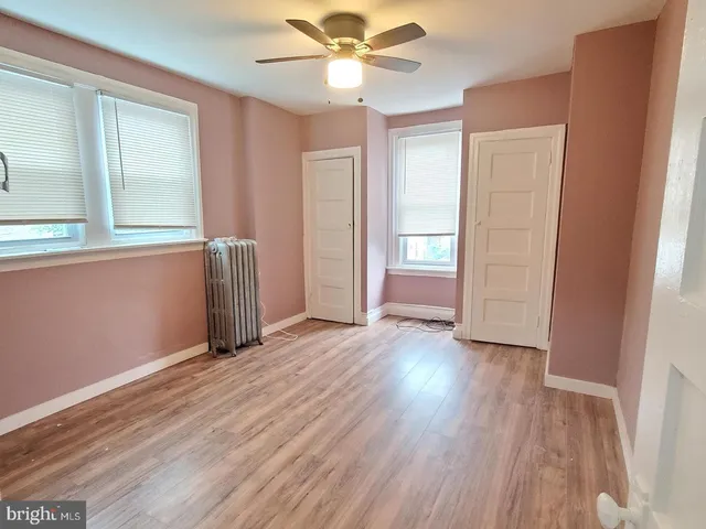 a view of an empty room with wooden floor