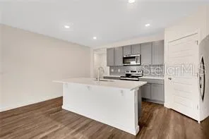 a kitchen with granite countertop a refrigerator stove top oven and sink