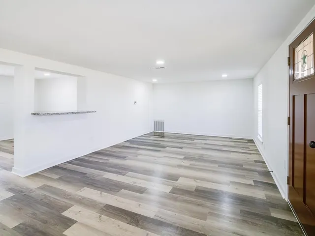a view of empty room with wooden floor