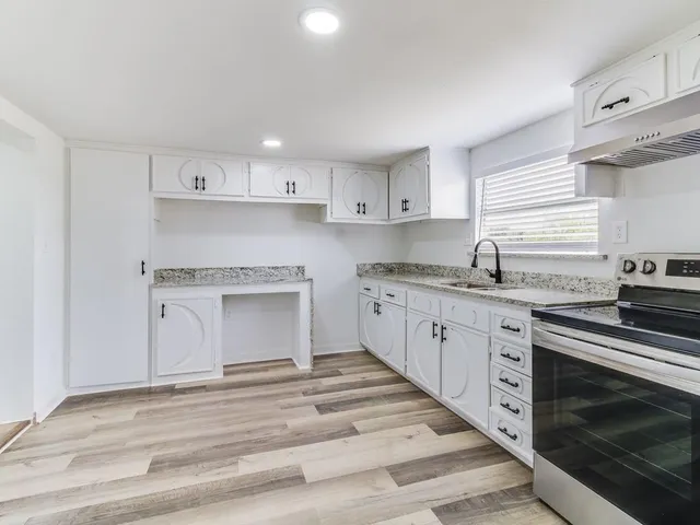 a kitchen with granite countertop white cabinets and white appliances