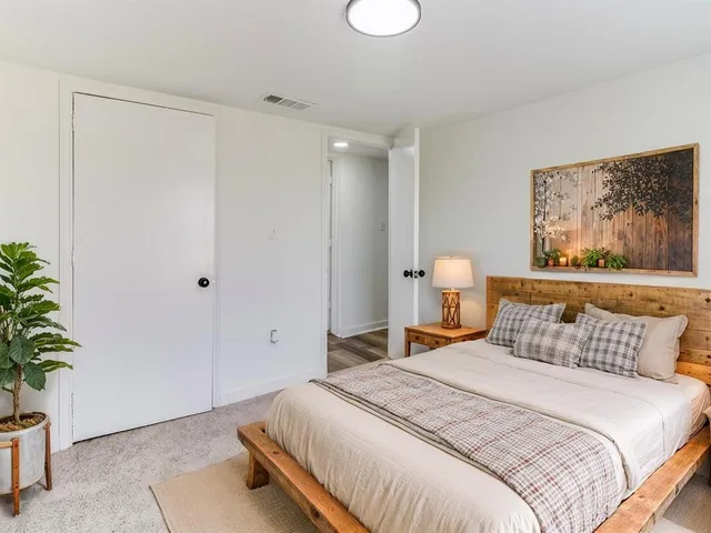 a bedroom with a bed and a potted plant