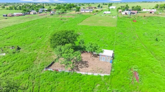 an aerial view of residential houses with outdoor space and trees all around