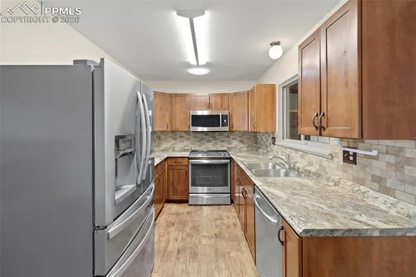 a kitchen with stainless steel appliances granite countertop a sink stove and refrigerator