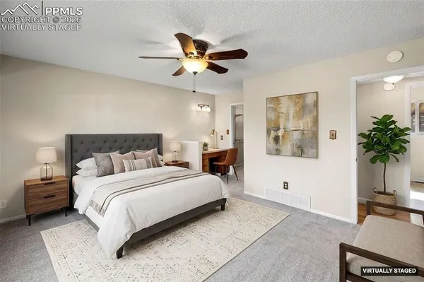 a bedroom with a large bed and a chandelier