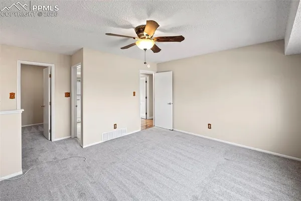 a view of an empty room with a ceiling fan