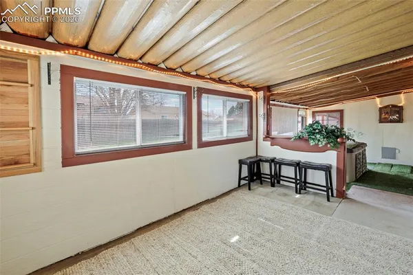 a porch area with table and chairs