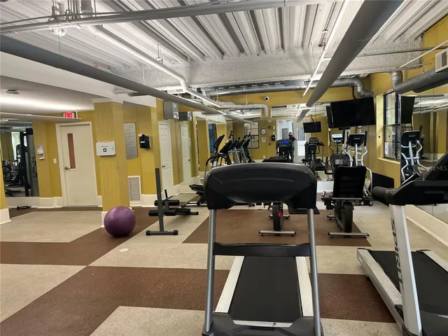 a room with gym equipment and large mirror