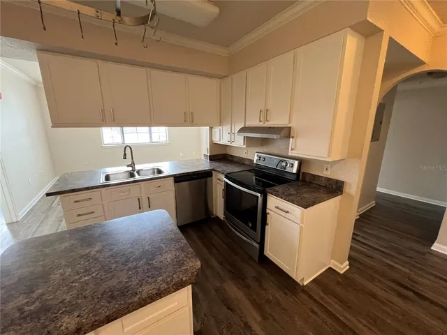 a kitchen with stainless steel appliances granite countertop a sink a stove and a refrigerator