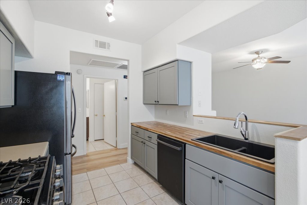 9050 West Warm Springs Road, Unit 1033 Las Vegas, NV 89148 - Photo 6 of 26 A contemporary kitchen space boasts sleek appliances and light wood countertops, offering a perfect blend of style and utility.