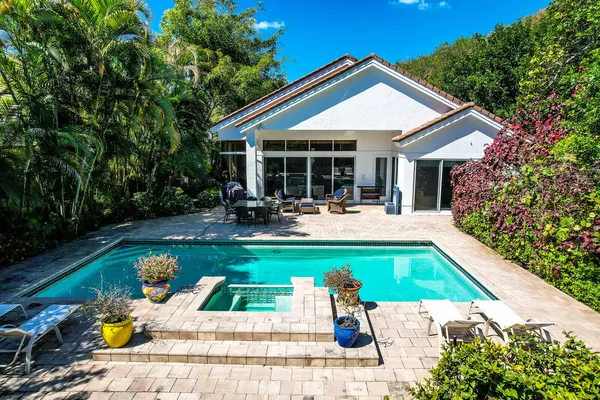 a view of house with swimming pool and garden