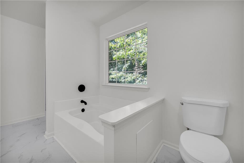 2941 Lake Hollow Road Gainesville, GA 30501 - Photo 31 of 53 a white toilet sitting next to a bath tub