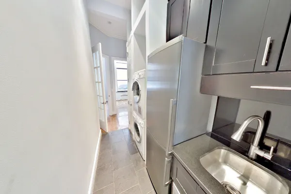 a kitchen with a refrigerator and a wooden floor