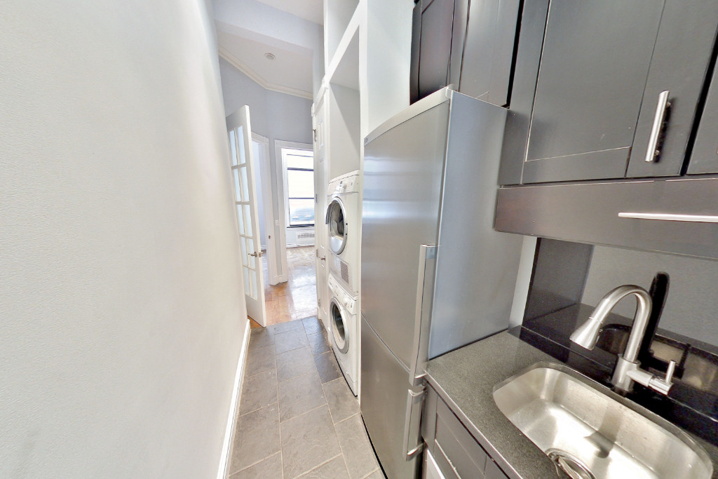 424 West 51st Street, Unit 2 Manhattan, NY 10019 - Photo 3 of 9 a kitchen with a refrigerator and a wooden floor