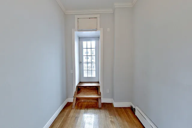 a room with wooden floor and a window